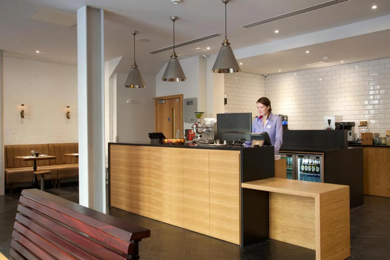 a woman standing at a counter in a restaurant at The Z Hotel Glasgow in Glasgow