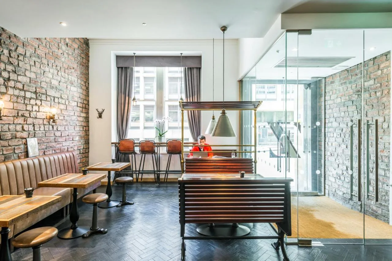 a restaurant with tables and chairs and a brick wall at The Z Hotel Glasgow in Glasgow